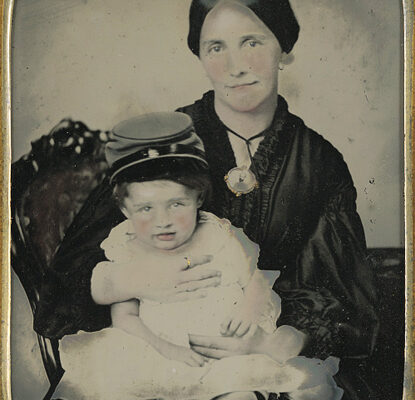 A young Civil War widow holding a child wearing a kepi circa 1861